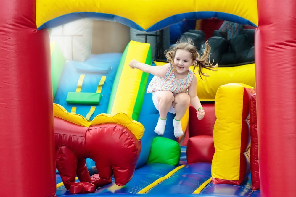 Child Jumping On Colorful Jumping Castle